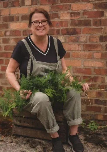 expert florist Fleur offering guidance to workshop participants on flower arranging techniques.