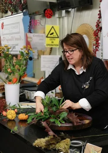 Floral designer arranging seasonal flowers during a flower arranging class in Liverpool