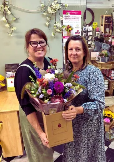 Student proudly holding their handtied bouquet after completing the flower arranging workshop.